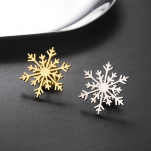 Détail macro de broches flocon de neige dorées et argentées en acier inoxydable poli
