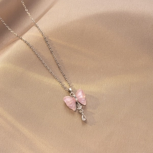 Detalle del colgante de mariposa rosa con circonita de lágrima en satén champán