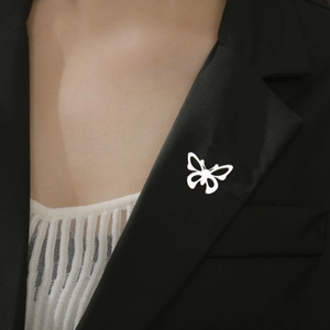 Gros plan d'une broche papillon argentée sur un revers de costume noir poli et élégant