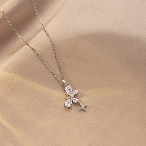 Detalle del collar de titanio plateado con mariposa de circonita y una estrella brillante