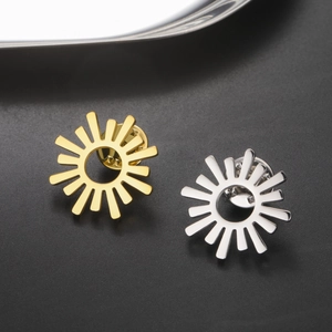 Vue macro de broches soleil dorées et argentées avec fermoirs papillon sécurisés