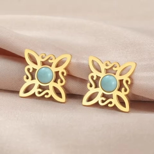 Macro view of Celtic witch knot earrings with blue stones on pink satin fabric