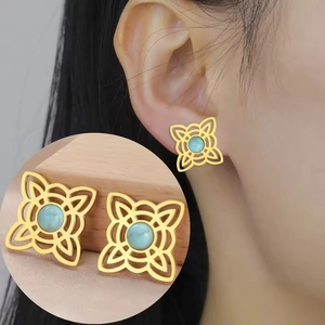 Detailed close-up of golden Celtic knot earrings featuring a blue turquoise centerpiece