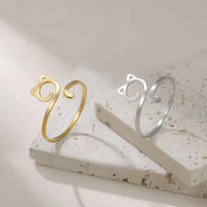 Adjustable cute cat rings in 18K gold and silver finishes on white stone pedestals