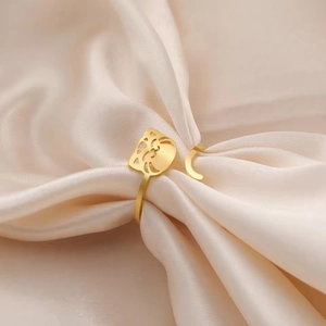 Macro view of 18K gold plated cute cat ring on soft pink silk fabric background