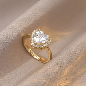 Détail d'une bague cœur ajustable avec grand zircon étincelant et halo de cristaux
