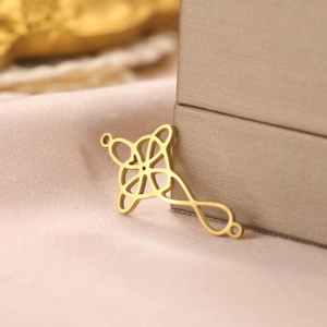 Detailed macro view of an 18k gold plated Celtic knot pendant with double hanging loops