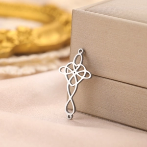 Macro shot of silver Celtic knot pendant resting on a champagne luxury jewelry box