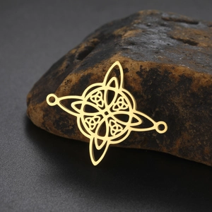 Macro detail of gold plated stainless steel Celtic knot pendant on natural stone base