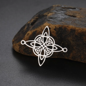 Macro shot of polished 18k gold plated stainless steel Celtic knot pendant with witch knot