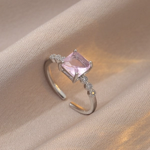 Bague réglable en argent avec zircon carré rose et pierres sur satin champagne