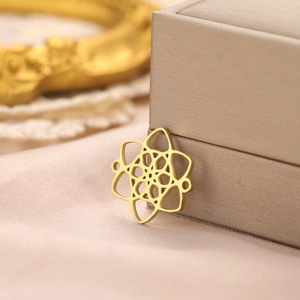Macro shot of 18k gold plated hollow Celtic witch knot pendant on elegant silk fabric
