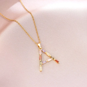 Vue détaillée du pendentif lettre A doré serti de pierres précieuses multicolores taille baguette