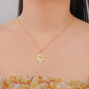 Vue détaillée d'un pendentif étoile de David doré avec accents bleus au cou