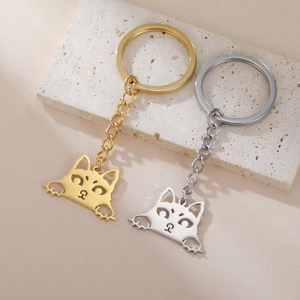 Detailed macro view of the gold and silver cartoon cat pendants with hollowed faces