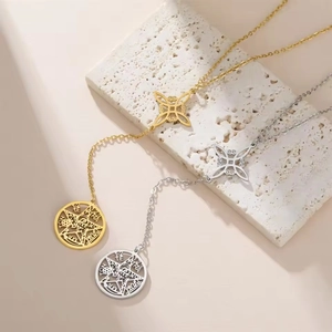 Detail of gold and silver stainless steel wicca necklaces on a textured stone base