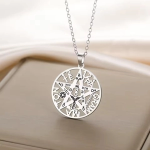 Macro detail of silver stainless steel pendant with hollow pentagram and mystic engraving