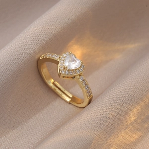 Détail de la bague dorée ajustable avec un grand zircon en cœur et sertissage pavé