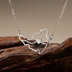 Macro detail of Martinique map pendant with heart on natural wood texture background