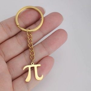Close-up of golden stainless steel Pi symbol pendant keychain held in hand
