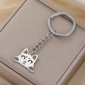 Detailed view of silver stainless steel cartoon cat keychain on a brown jewelry gift box