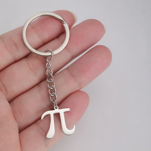 Macro shot of silver stainless steel Pi symbol pendant keychain held by hand