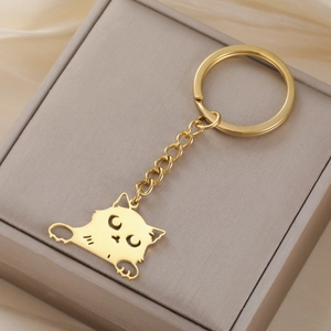 Detailed view of a golden cartoon cat keychain on a textured jewelry gift box
