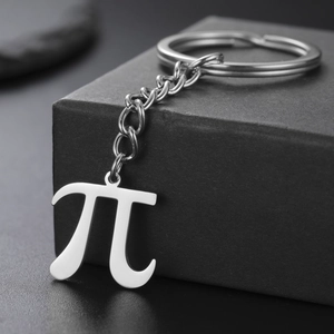 Detailed close-up of a polished stainless steel Pi symbol keychain on a premium gift box