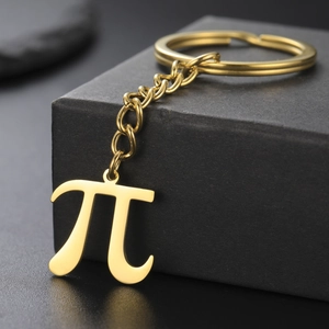 Macro side view of golden Pi symbol keychain on a premium black textured gift box