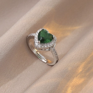 Détail d'une bague ajustable en argent avec zircon vert en forme de cœur sur soie