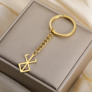 Detail shot of golden Brand of Sacrifice pendant on elegant silk and jewelry box