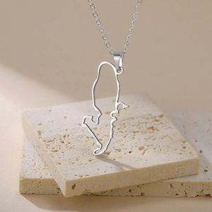 Macro detail of silver stainless steel cutout map pendant on a fine link chain necklace
