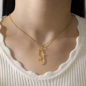 Detail view of a hollow Venezuela map pendant on a gold stainless steel necklace for women