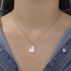 Polished stainless steel girl and dog silhouette pendant necklace on a denim model