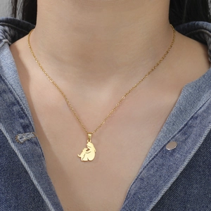 Close-up of a gold minimalist silhouette pendant showing a girl hugging a dog on a neck