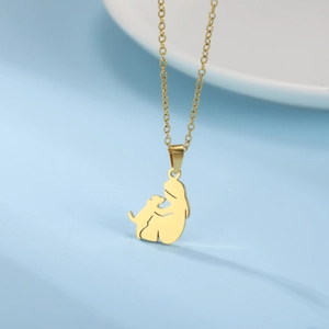 Detailed view of a gold-plated stainless steel girl and dog silhouette pendant necklace