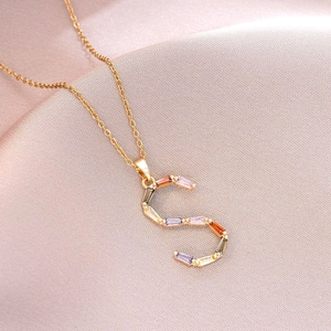 Gros plan sur le pendentif lettre S doré serti de cristaux multicolores et brillants