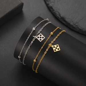 Detail view of gold and silver stainless steel chain bracelets with square charms