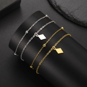 Set of four minimalist gold and silver stainless steel chain bracelets on display