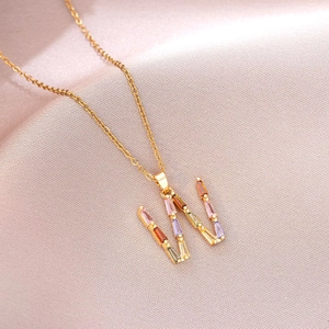 Collier en titane doré avec pendentif lettre W orné de zircons de couleur baguette