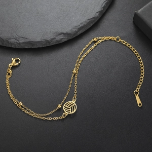 Detaillierte Makroansicht eines goldfarbenen Doppelkettenarmbands mit Volleyball-Anhänger