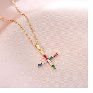 Collier élégant en titane doré avec pendentif croix en cristaux colorés sur du satin rose