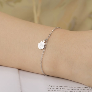 Elegant stainless steel cable chain bracelet featuring a delicate shell charm pendant