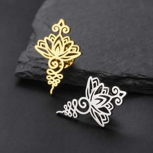Macro shot of silver and gold witch knot pins on textured dark stone surface
