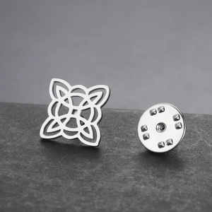 Macro view of silver stainless steel celtic knot brooch on dark stone surface