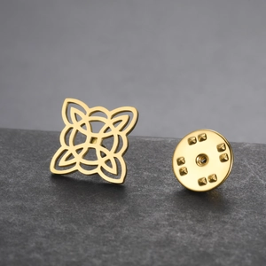 Macro detail of a golden stainless steel Wicca knot brooch with butterfly clutch backing