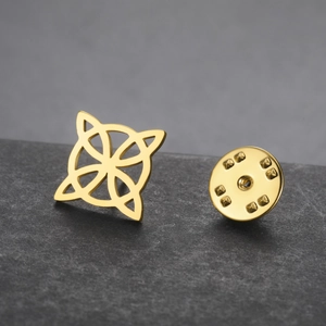 Macro detail of a golden stainless steel Celtic knot brooch with butterfly clutch
