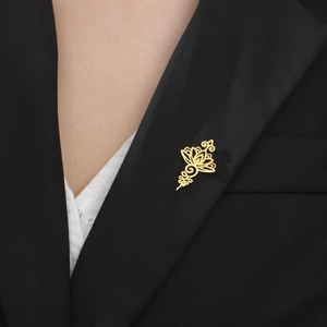 Elegant hollow lotus brooch pin in gold finish styled on a black suit blazer lapel