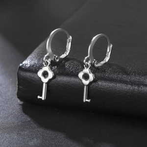 Dettaglio degli orecchini a chiave in argento con design a fiore su pelle scura