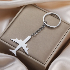 Polished 304 stainless steel airplane keychain with metal chain on silk background